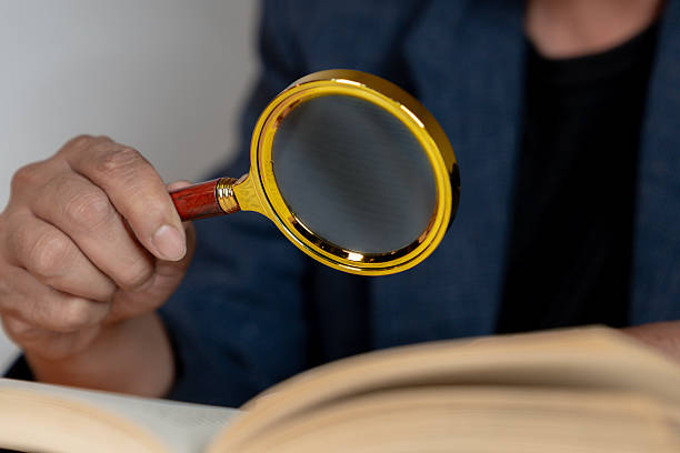 istock Close-Up of Elderly Man Reading with Magnifying Glass 2227692363