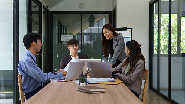 istock Group of businesspeople analyzing documents and sharing ideas at a modern office table. 2227695912