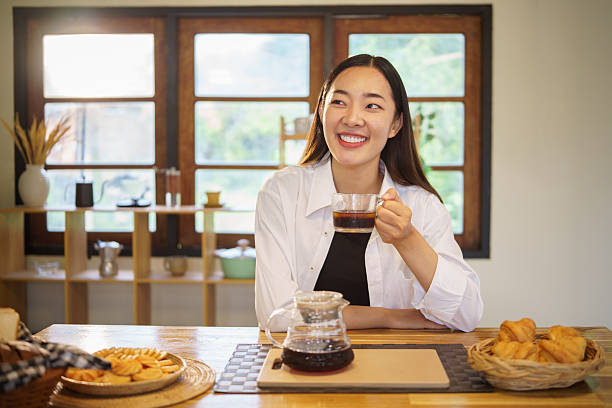 istock Smiling young woman enjoying a hot drink while standing in a cozy kitchen. 2227696554