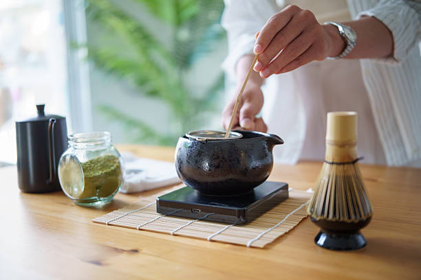 istock Close up of hands making ceremonial green tea with authentic matcha tools on a kitchen counter. 2227696840