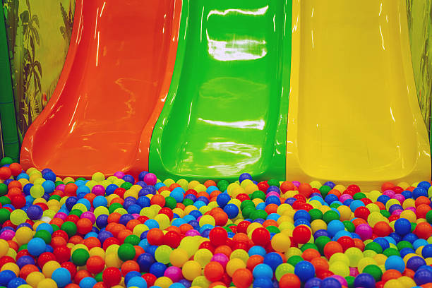 istock Three brightly colored slides stand next to a colorful ball pit filled with vibrant plastic balls, inviting children to play and explore at a lively indoor playground. 2227697102