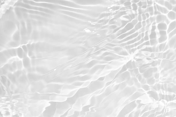 istock White water with ripples on the surface. Defocus blurred transparent white colored clear calm water surface texture with splashes and bubbles. Water waves with shining pattern texture background. 2227697120