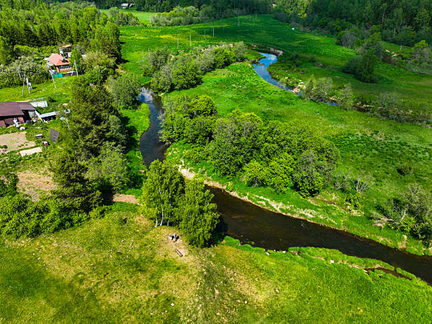 istock Rural landscape with winding river, houses, and green fields 2227700940