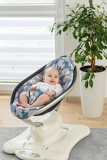 istock Smiling baby relaxing in modern baby swing 2227702202