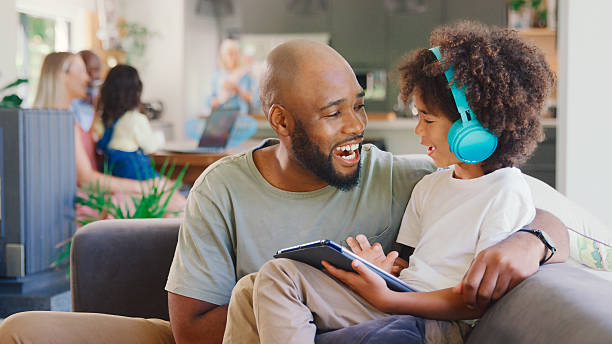 istock Father And Son Using Digital Tablet At Home With Multi-Generation Family In Background 2227703461