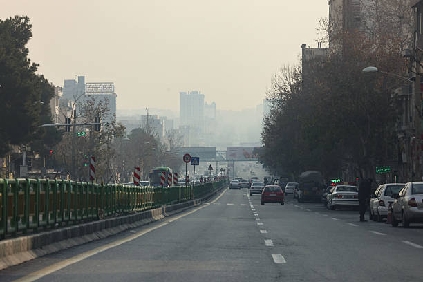 A thick layer of smog blankets the skyline of Tehran, the capital of Iran, obscuring mountains and buildings in the distance. The dense pollution is a recurring environmental crisis, posing serious health risks to millions of residents each year