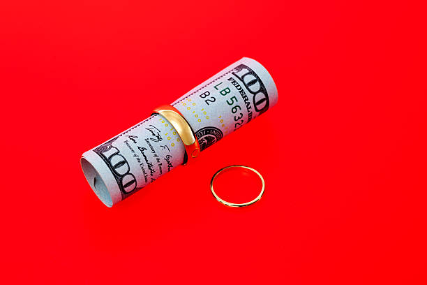 Wedding rings and US paper currency on red background