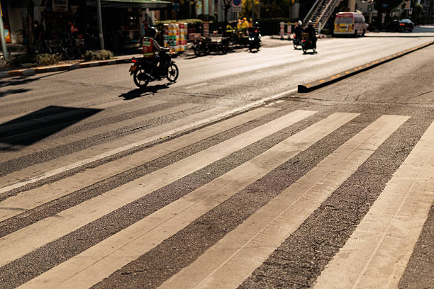 istock Sunny Crosswalk with Passing Motorcyclists in Background 2227706521