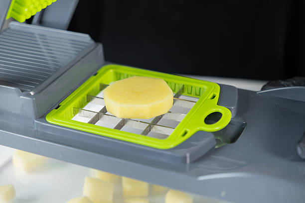 istock A green and grey vegetable chopper with a raw potato slice poised for dicing, highlighting kitchen efficiency for quick, healthy meal preparation 2227706713