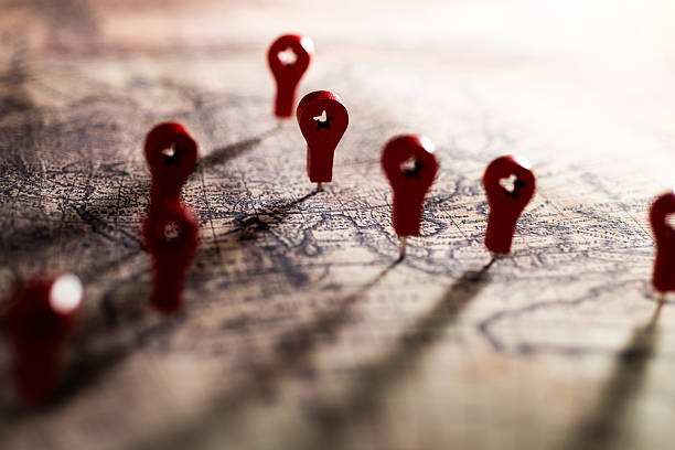 istock Group of red map pins in a vintage map with shadow 2227706906
