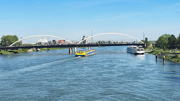 The river Rhine with two ships in Kehl.\nThe Europa Bridge can be seen in the background. It connects Germany with France.