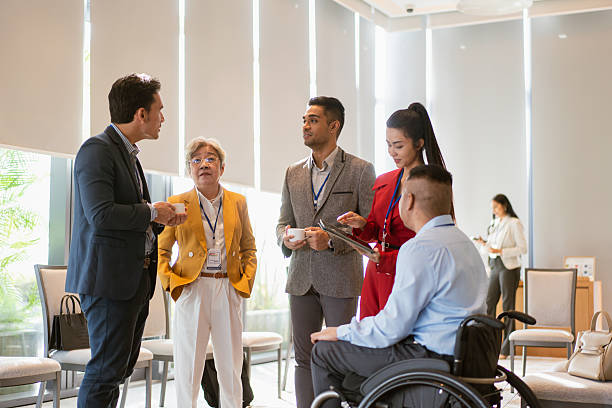 istock Group of business professionals congregate and network during a conference break 2227709602