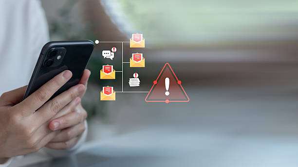 istock Close-up hand holding smartphone with warning icon and phishing email notification. Concept of cybersecurity threats, email scams, data breaches, and mobile fraud. 2227710221