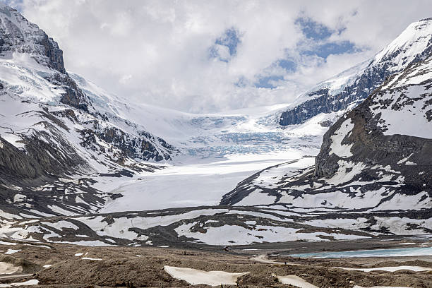 Beautiful spring scene capturing the Athabasca Glacier, part of the Columbia Icefield, surrounded by snow-dusted mountains within Jasper National Park. Located in the Canadian Rocky Mountains, it inspires awe and appreciation for nature.