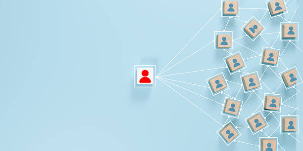 istock Leadership, organizational hierarchy, communication, and team structure dynamics. Red person icon on white block connected to blue icons on wooden blocks. 2227711993