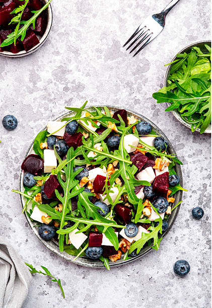 istock Gourmet salad with beet, blueberries, cheese, arugula and walnuts, gray table background, top view 2227712612
