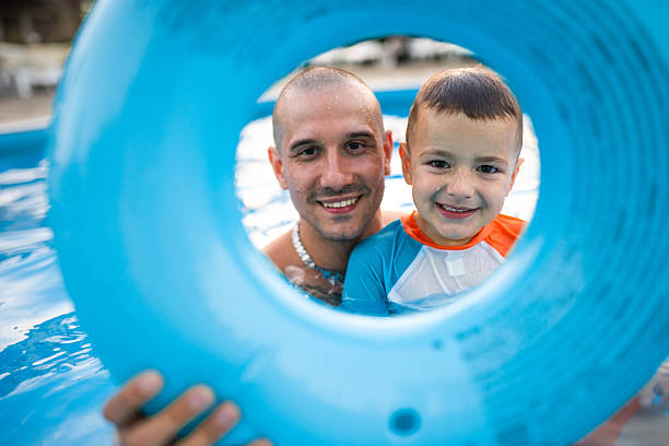 istock Cheerful father and son having fun in the swimming pool. 2227712674