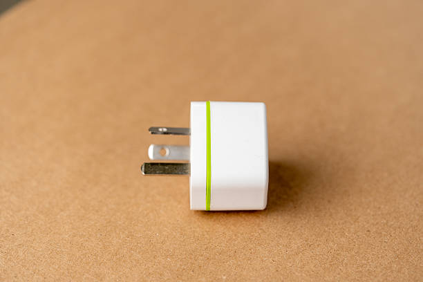 A white charger with a green stripe sits on a brown surface