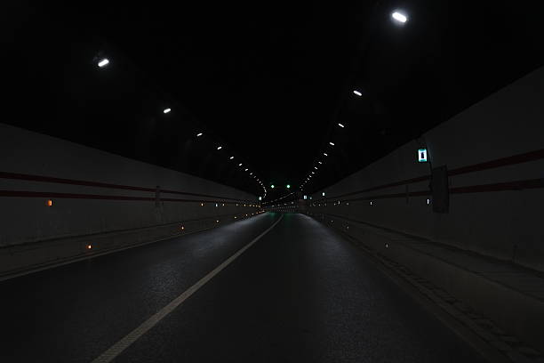 istock Empty Highway Tunnel with Illuminated Lights and Curved Road 2227716403