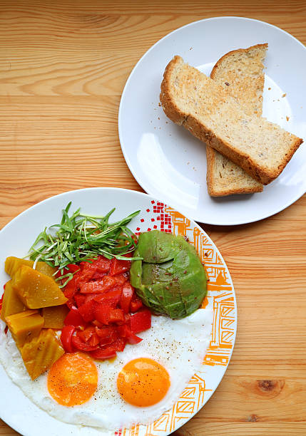 Healthy breakfast of sunny-side up with microgreen and avocado salad