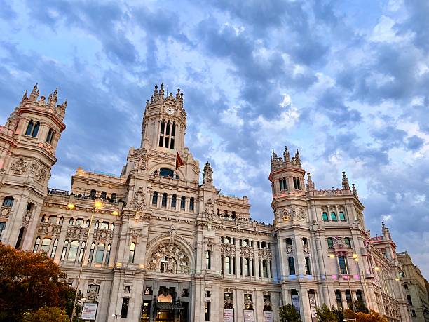Madrid, Spain - July 5, 2025: Cybele Palace, the City Hall of Madrid, illuminated with rainbow colors during Madrid Gay Pride (MADO), showing support for the LGBTIQ community under a cloudy sky at sunset.