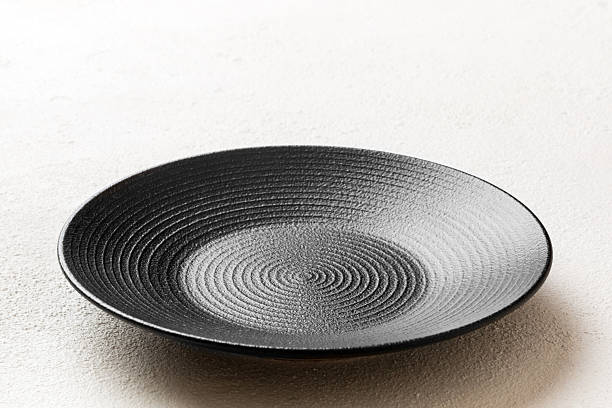 istock Perspective view of empty black plate on cement background. Empty space for your design 2227720745