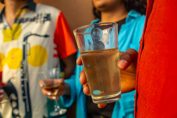 Hand holding a glass of orange drink