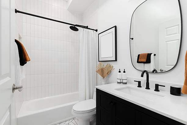 istock A bathroom with a black cabinet, white walls, and a vertical subway tile shower. 2227726062
