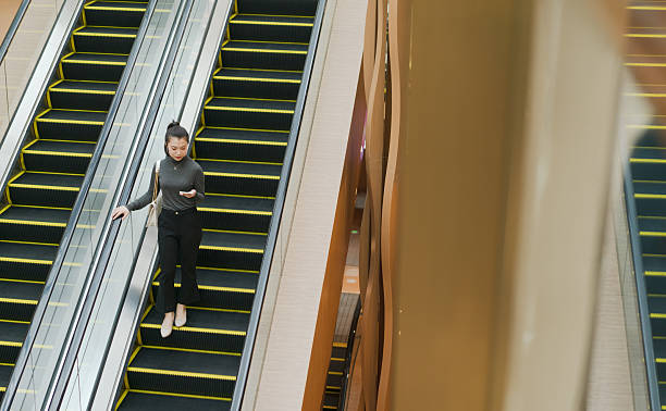 Woman on escalator in shopping mall