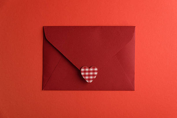 Close red envelope witl love letter and hearts on red background. Valentines day celebration