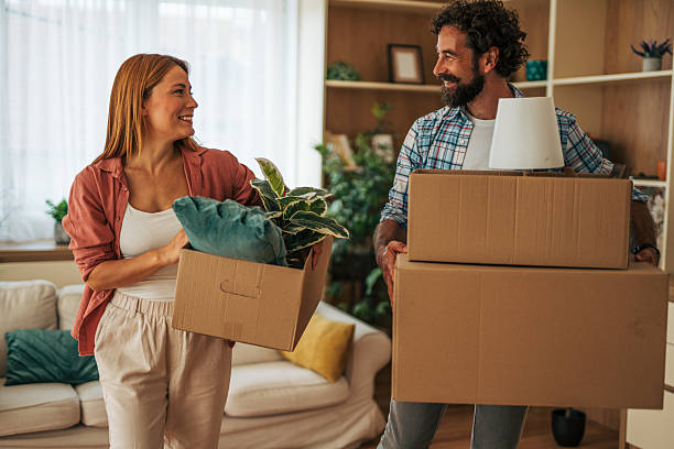 istock Couple carrying boxes while moving into new home 2227736548