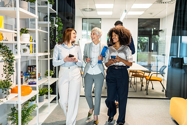 istock Businesswomen smiling and walking through modern office corridor 2227736591