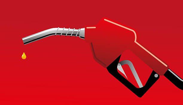 istock Fuel dripping from a red gas pump nozzle on red background 2227736964