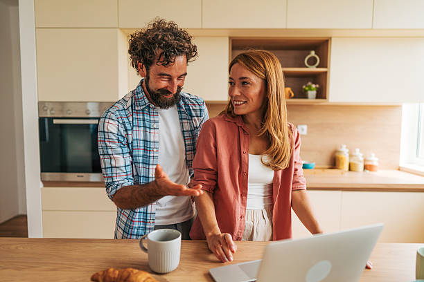 istock Couple using laptop and discussing in kitchen at breakfast time 2227737103