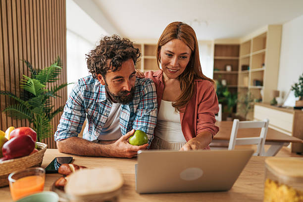 istock Couple using laptop in kitchen and having healthy breakfast 2227737105