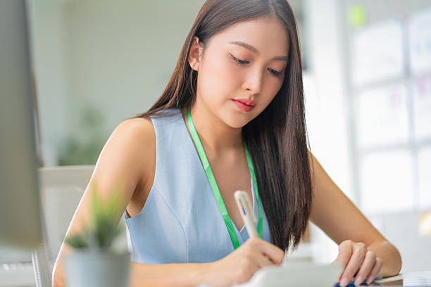istock young businesswoman is actively using a computer at her desk in the office. She's focused on working on the computer in the office, showcasing her professional dedication 2227737998