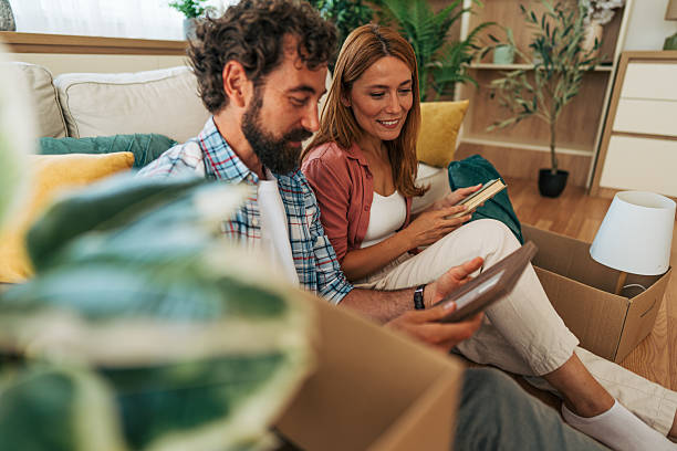istock Couple unpacking boxes in new home and taking out picture frame 2227738243