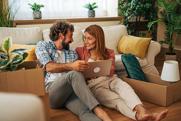 istock Couple using laptop while moving into new home 2227738612