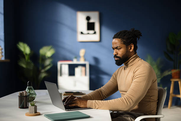 istock Focused young businessman working on laptop in modern office 2227739656