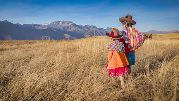 Peruvian woman crossing a field, Urubamba Valley stock photo