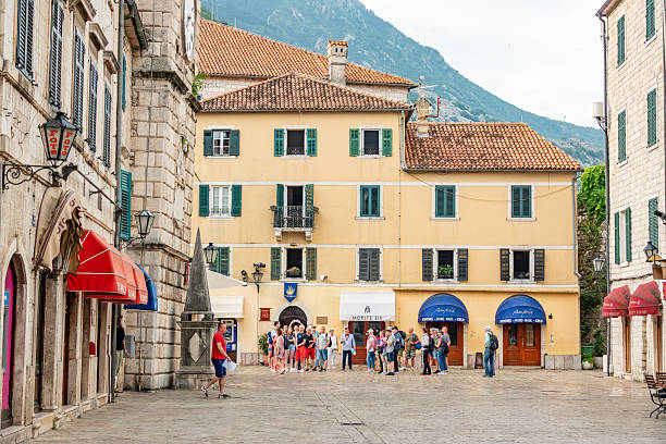 Kotor Old Town in Kotor Municipality, Montenegro, with many people and stores visible.