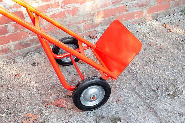 istock hand truck against brick wall. Device with platform for carrying cargo 2227751087