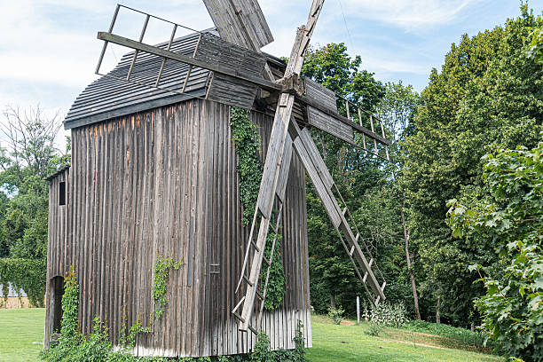 istock An ancient windmill in a rural Central European village, with grassy fields and trees The wooden structure has multiple blades, is weathered, and partially overgrown Naturalistic colors dominate g 2227751237