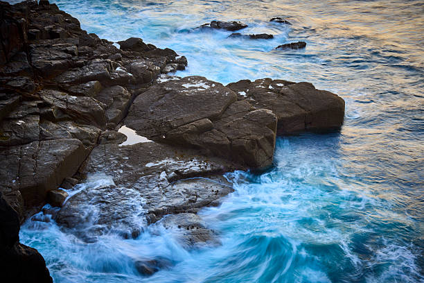 View of ocean waves breaking on rocky beach, Cornwall, UK with long exposure time