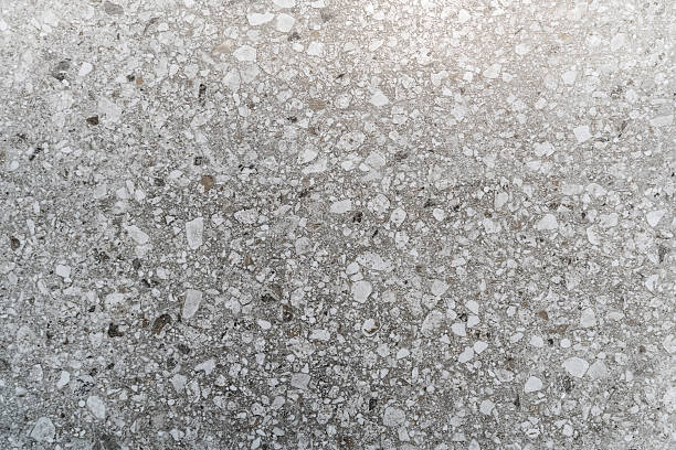 Close-up of a polished terrazzo surface featuring grey tones and scattered white marble fragments. Ideal for backgrounds, modern design concepts, and architectural elements.