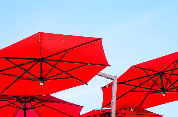 istock Red sun umbrellas against deep blue sky on a bright summer beach day 2227757734