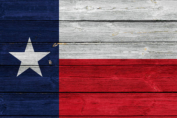 Texas state flag on an old wooden surface with cracked paint.