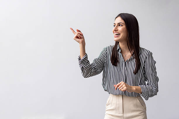 istock Professional businesswoman gesturing cheerfully while presenting corporate solution against clean white backdrop 2227761582