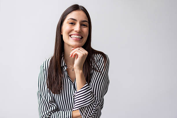 istock Confident female professional leaning hand on chin, smiling warmly while facing camera in minimalist office setting 2227762063