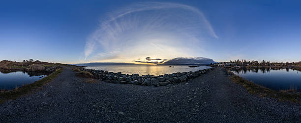 Coastal pathway with panoramic sunset reflecting on tranquil harbor in Victoria, Canada.